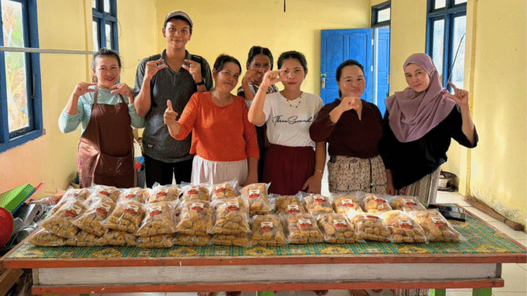 Ibu-ibu Desa Pelapis dan tim CSR PT Dharma Inti Bersama menunjukkan nugget ikan hasil produksi kelompok.